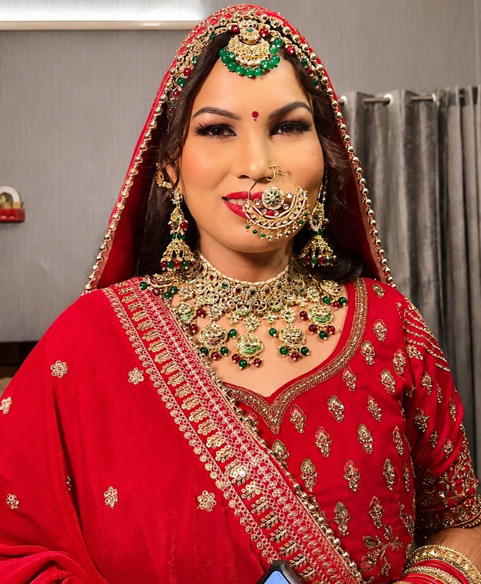 The same client in full red bridal wear with gold jewellery, wearing a warm luminous finish